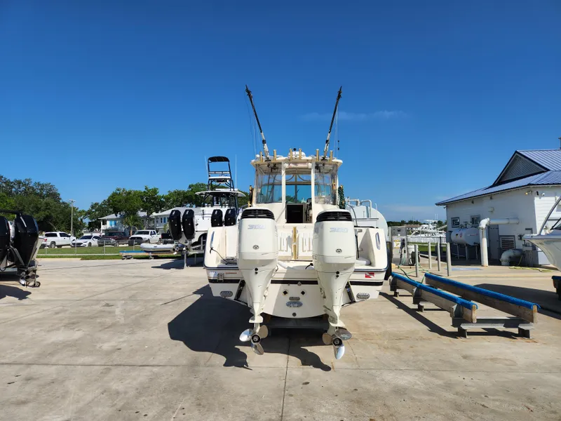 Slide: The Image of 2005 Pursuit 3070 Offshore Center Console boat with dual outboard engines, parked on concrete. - 5