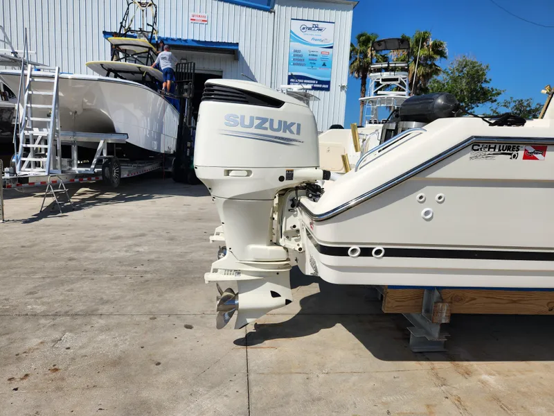 Slide: The Image of 2005 Pursuit 3070 Offshore Center Console with Suzuki outboard motor in a boatyard. - 9