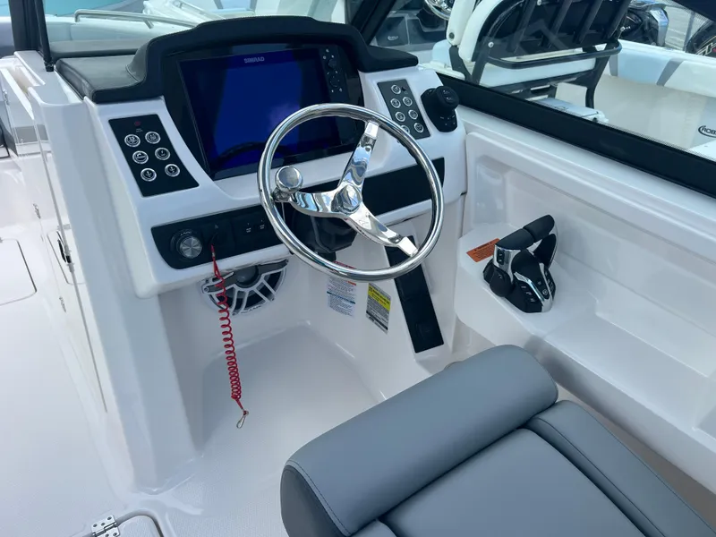 Slide: The Image of 2025 Robalo R257 Dual Console boat cockpit with steering wheel and control panel. - 10