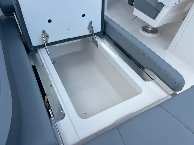 Slide: The Image of 2025 Robalo R257 Dual Console boat storage compartment, open and empty. - 15