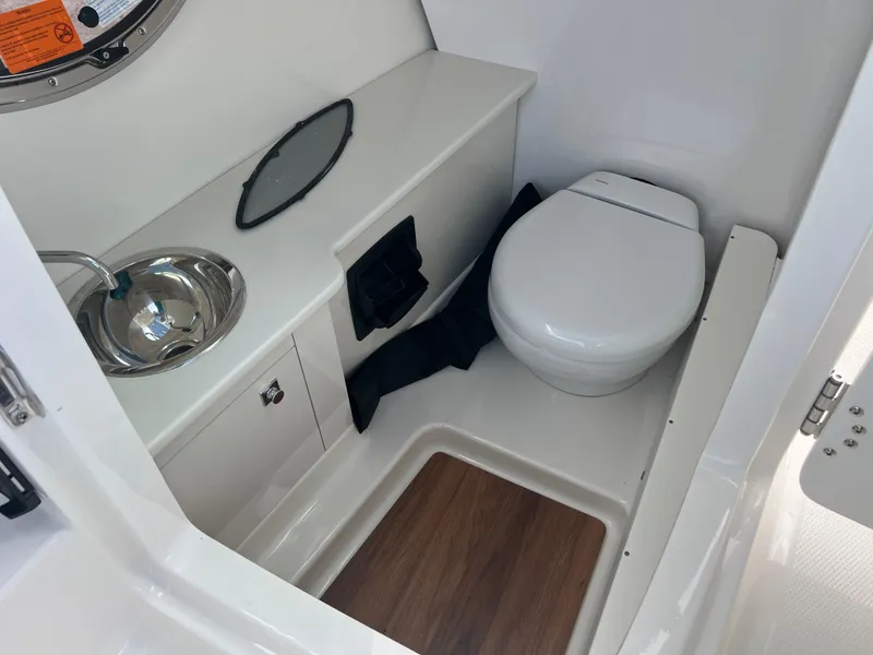 Slide: The Image of 2025 Robalo R257 Dual Console boat bathroom with sink and toilet. - 17