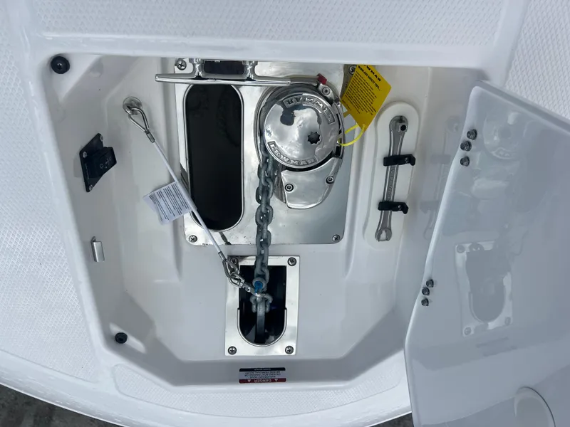 Slide: The Image of Anchor compartment of 2025 Robalo R257 Dual Console boat, featuring chain and storage. - 19