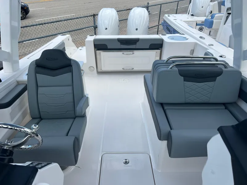 Slide: The Image of 2025 Robalo R257 Dual Console boat interior with gray seating and dual engines. - 24