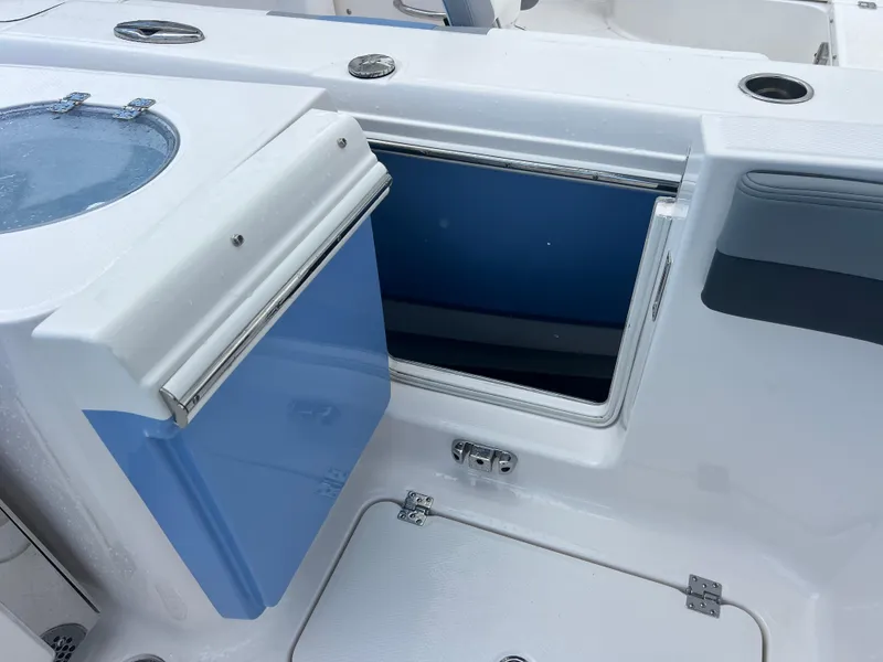 Slide: The Image of 2025 Robalo R257 Dual Console boat with open storage compartment and livewell. - 26
