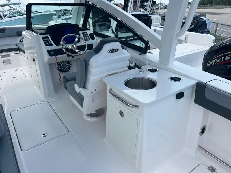 Slide: The Image of 2025 Robalo R257 Dual Console boat interior with helm, sink, and seating area. - 9