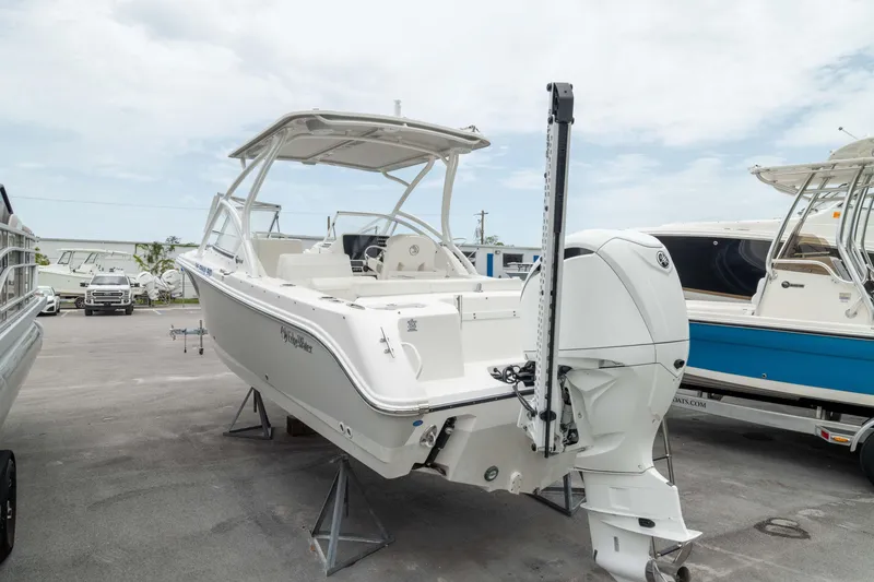 Slide: The Image of 2023 Edgewater 248 CX boat on display, featuring sleek design and modern outboard motor. - 1