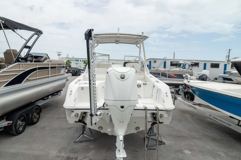 Slide: The Image of 2023 Edgewater 248 CX boat displayed in a marina, rear view. - 12