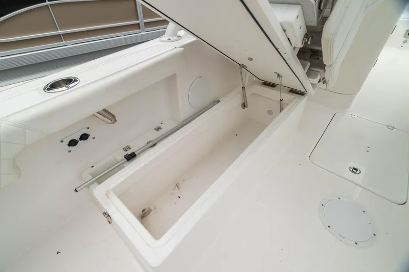 Slide: The Image of 2023 Edgewater 248 CX boat interior storage compartment, open and spacious design. - 14