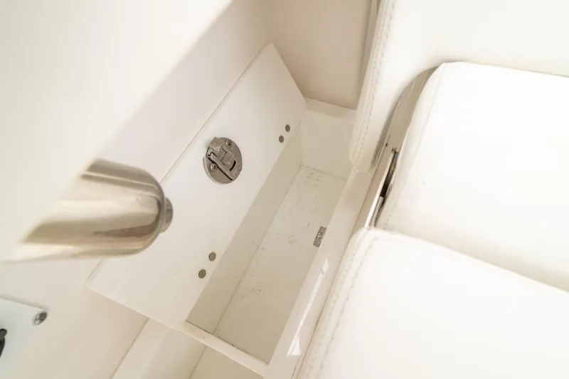 Slide: The Image of 2023 Edgewater 248 CX boat interior storage compartment with stainless steel details. - 16