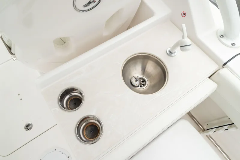 Slide: The Image of 2023 Edgewater 248 CX boat sink and cup holders on white deck. - 19