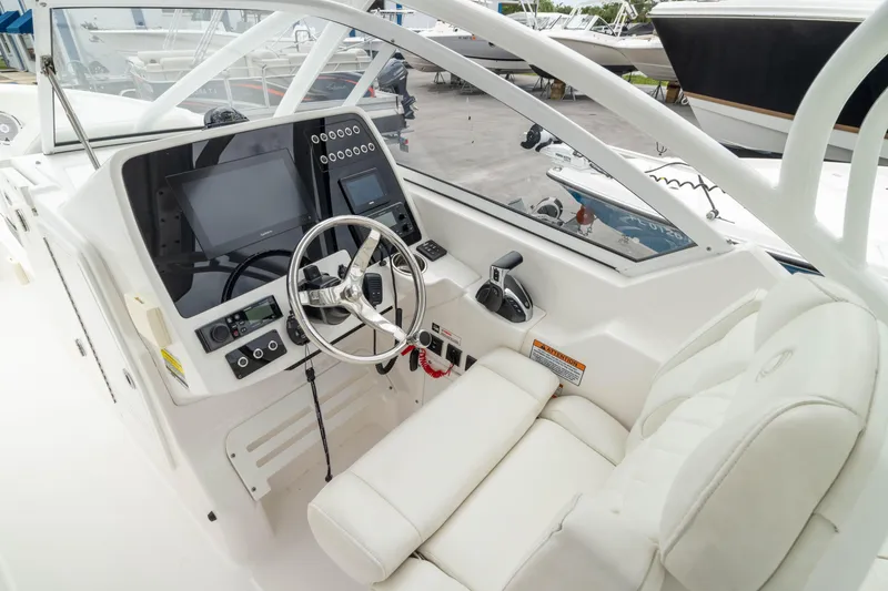 Slide: The Image of 2023 Edgewater 248 CX boat cockpit with modern controls and white seating. - 2