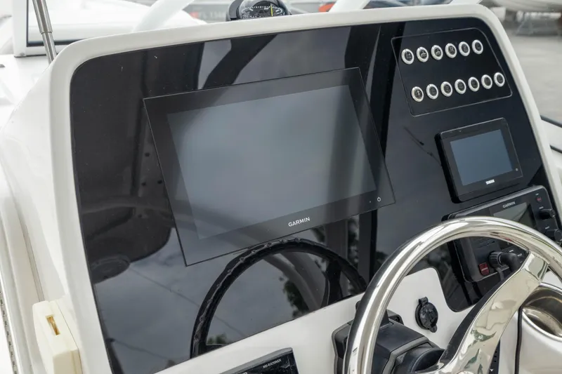 Slide: The Image of 2023 Edgewater 248 CX dashboard with Garmin display and control panel. - 25