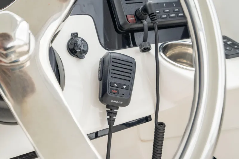 Slide: The Image of 2023 Edgewater 248 CX boat dashboard with Garmin radio microphone and steering wheel. - 28