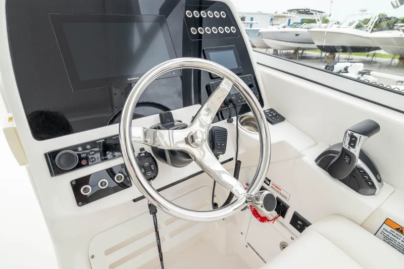 Slide: The Image of 2023 Edgewater 248 CX boat dashboard with steering wheel and control panel. - 30