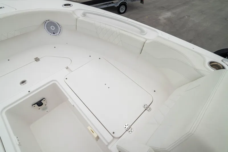 Slide: The Image of 2023 Edgewater 248 CX boat interior with white seating and storage compartments. - 39