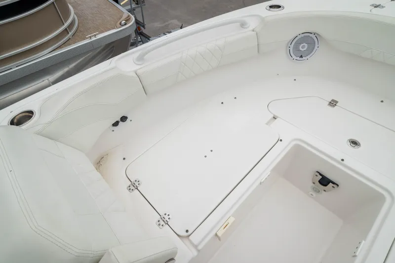 Slide: The Image of 2023 Edgewater 248 CX boat interior with white seating and storage compartments. - 40