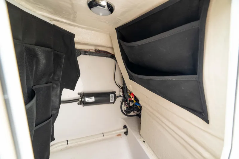 Slide: The Image of Interior storage compartment of 2023 Edgewater 248 CX boat, featuring organized wiring and storage pockets. - 46