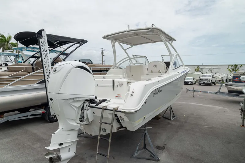 Slide: The Image of 2023 Edgewater 248 CX boat displayed outdoors, featuring a sleek design and powerful outboard motor. - 8