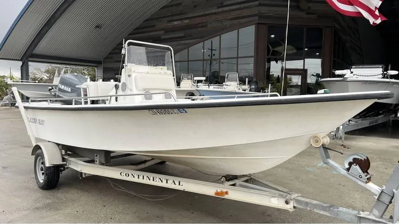 Slide: The Image of 2000 Blazer 186 boat on trailer, parked outside a building with an American flag. - 11