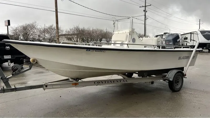 Slide: The Image of White Blazer 186 boat from 2000, parked outdoors on a cloudy day. - 7