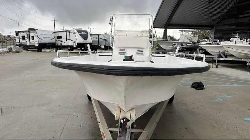 Slide: The Image of 2000 Blazer 186 boat console with steering wheel, gauges, and rod holders in a marina setting. - 9