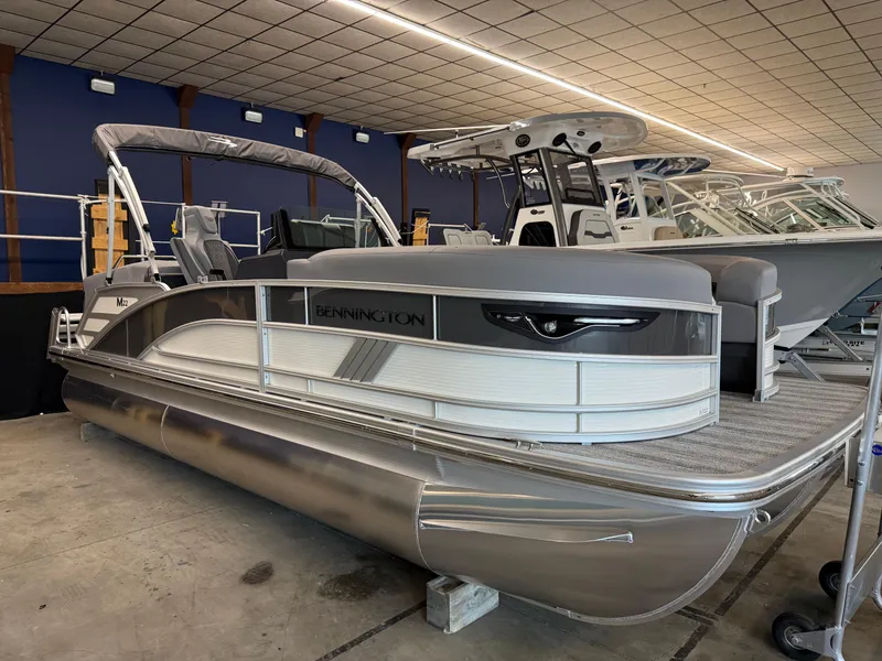 The Image of 2025 Bennington M Line pontoon boat in showroom, sleek design, modern features. - 0