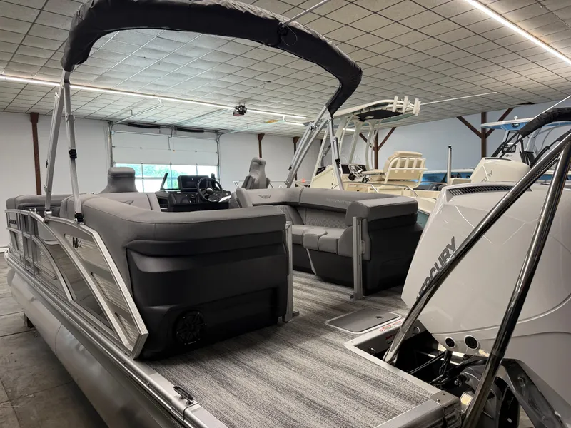 Slide: The Image of 2025 Bennington M Line pontoon boat with Mercury engine in showroom. - 11