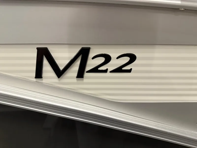 Slide: The Image of 2025 Bennington M Line M22 boat model emblem on sleek exterior. - 2