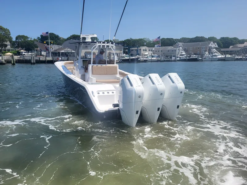 Slide: The Image of 2025 Front Runner 39 boat with triple engines in a marina setting. - 10