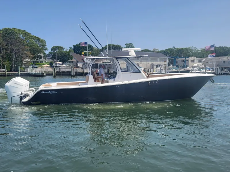 Slide: The Image of 2025 Front Runner 39 boat on calm water near a marina. - 17