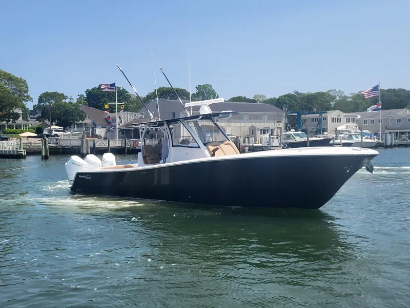 Slide: The Image of 2025 Front Runner 39 boat cruising in a marina with waterfront homes in the background. - 18