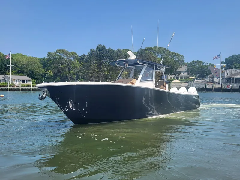 Slide: The Image of 2025 Front Runner 39 boat cruising on a sunny day in a scenic waterfront area. - 2