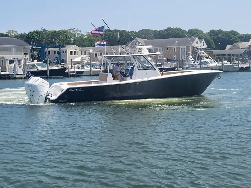 Slide: The Image of 2025 Front Runner 39 boat cruising in a marina with waterfront buildings in the background. - 20