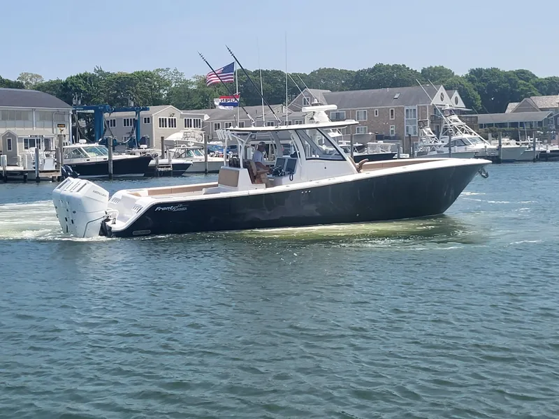 Slide: The Image of 2025 Front Runner 39 boat cruising in a marina with American flag in the background. - 21