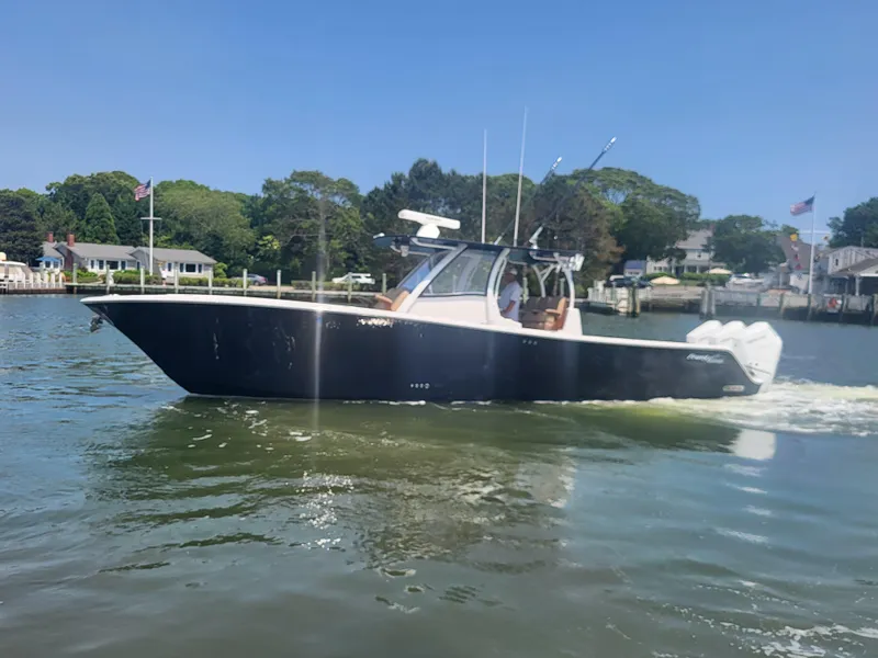 Slide: The Image of 2025 Front Runner 39 boat cruising on a sunny day near waterfront homes. - 3