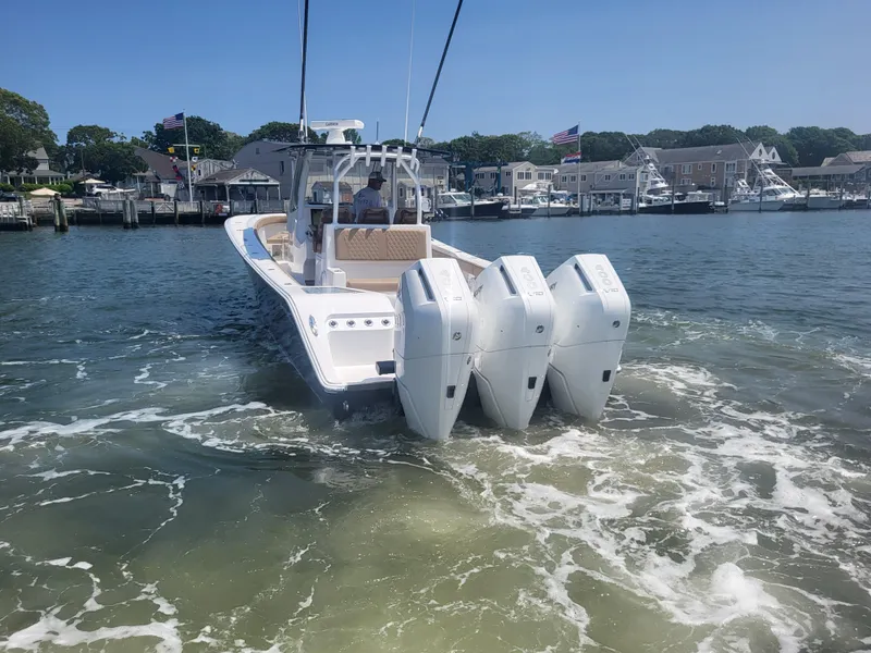 Slide: The Image of 2025 Front Runner 39 boat with triple engines cruising in a marina. - 8