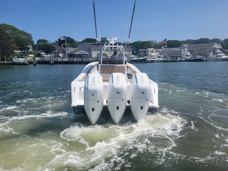 Slide: The Image of 2025 Front Runner 39 boat with triple engines cruising in a marina. - 9