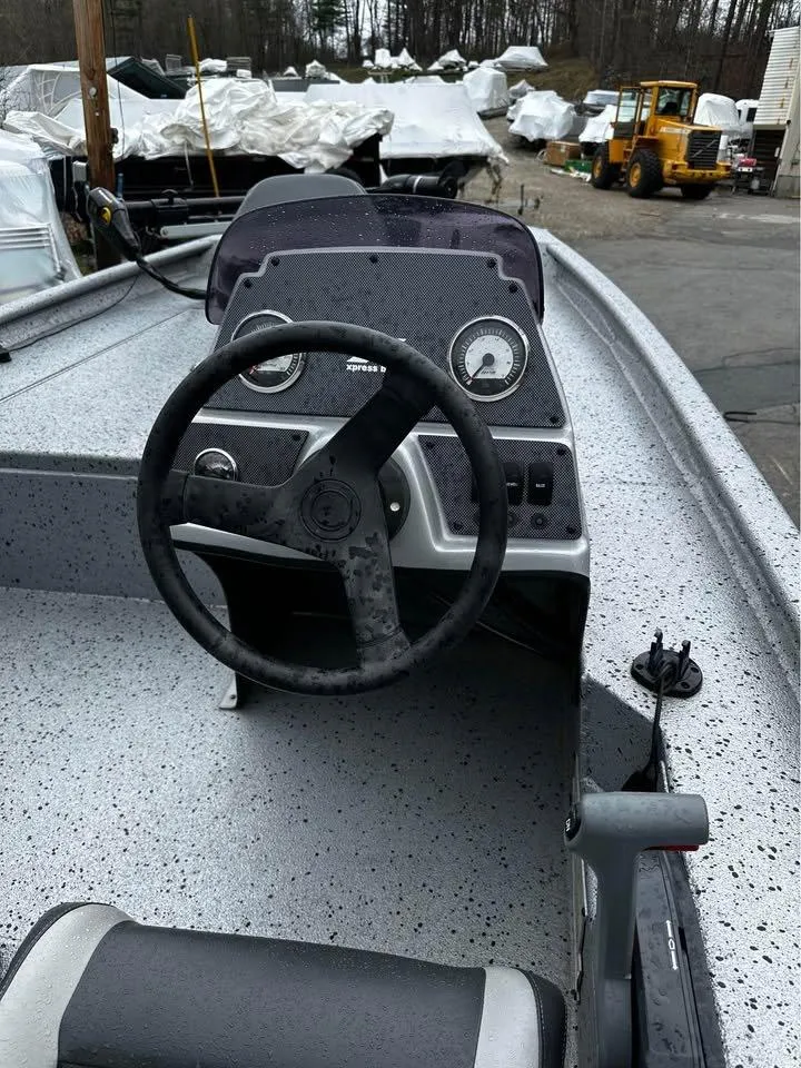 Slide: The Image of 2018 Xpress XP7 boat dashboard with steering wheel and gauges in a marina setting. - 4