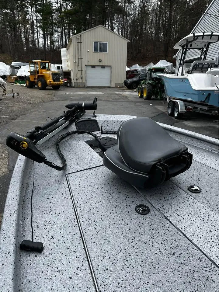 Slide: The Image of 2018 Xpress XP7 boat with trolling motor and seat, parked outdoors near a garage. - 5