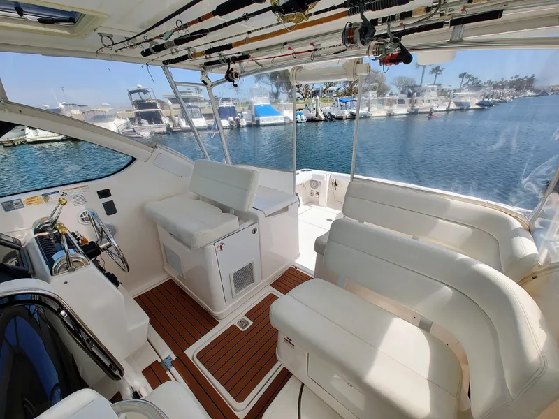 Slide: The Image of 2008 Tiara Yachts 3200 Open interior with white seating and fishing rods, docked at marina. - 17