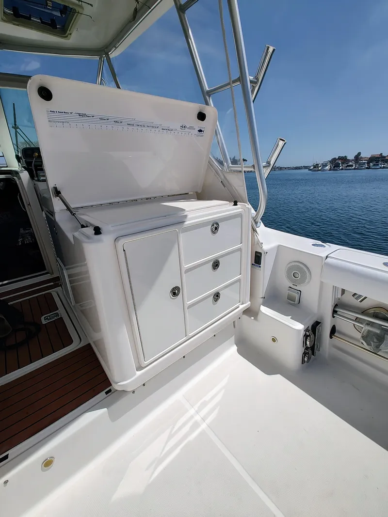 Slide: The Image of 2008 Tiara Yachts 3200 Open boat interior with storage compartments, docked by the water. - 21