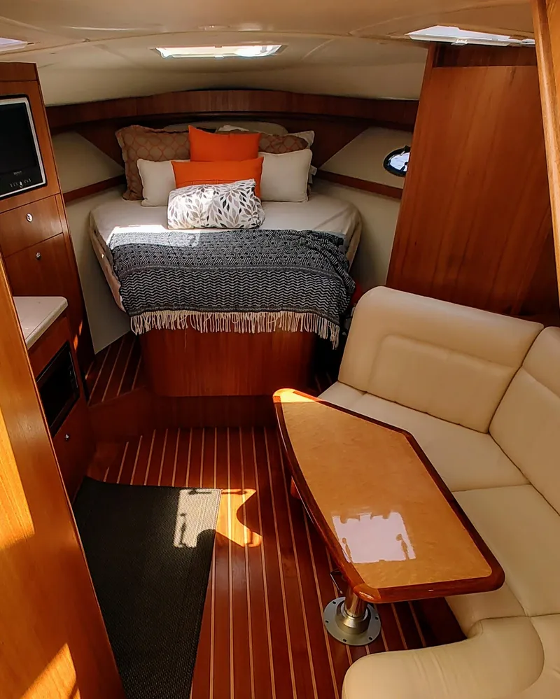 Slide: The Image of 2008 Tiara Yachts 3200 Open cabin with cozy bed, wooden interior, and seating area. - 25
