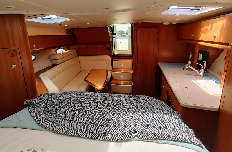 Slide: The Image of 2008 Tiara Yachts 3200 Open interior with cozy seating, kitchenette, and bed. - 26
