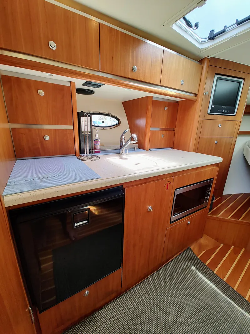 Slide: The Image of 2008 Tiara Yachts 3200 Open galley with wood cabinetry and modern appliances. - 31
