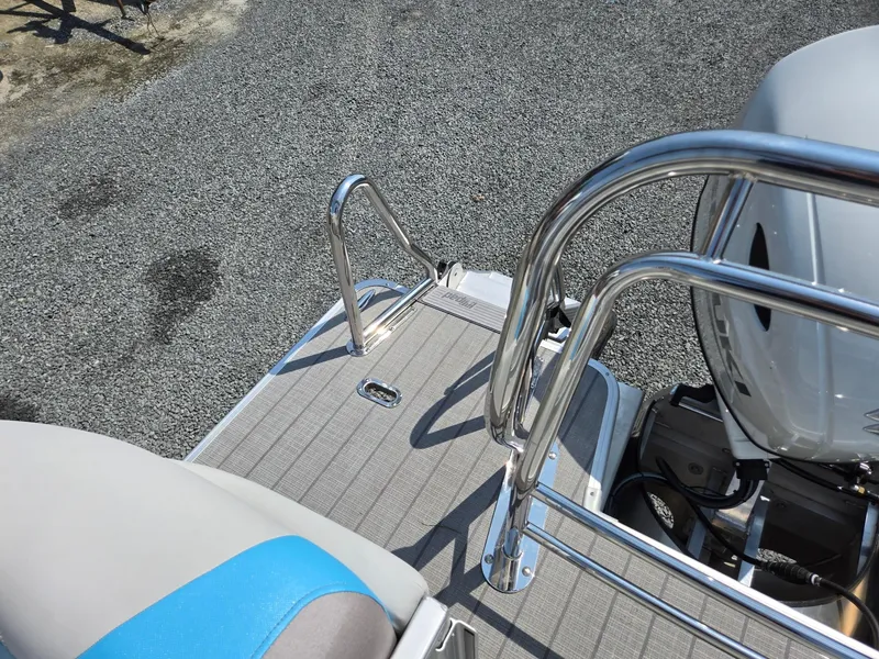 Slide: The Image of 2026 Godfrey SWEETWATER 2286 SB boat deck with stainless steel railings and motor. - 26