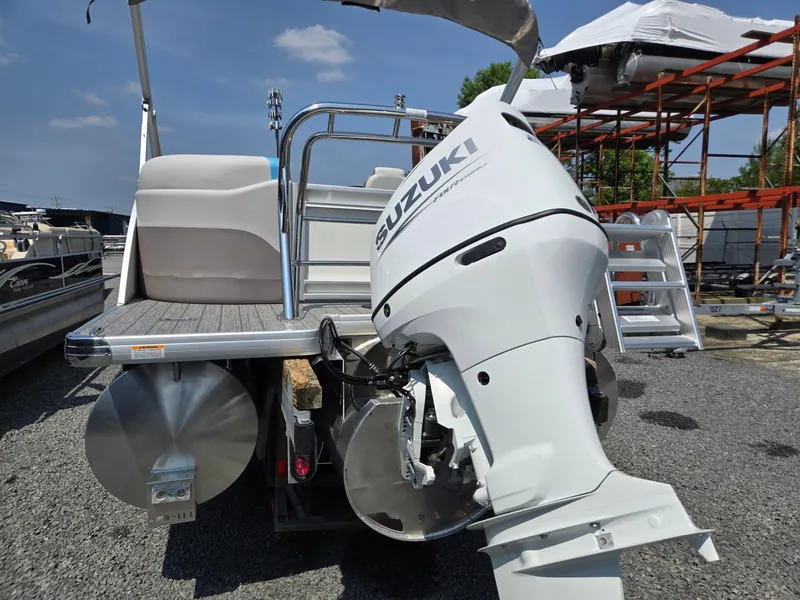 Slide: The Image of 2026 Godfrey SWEETWATER 2286 SB pontoon boat with Suzuki outboard motor, docked outdoors. - 3