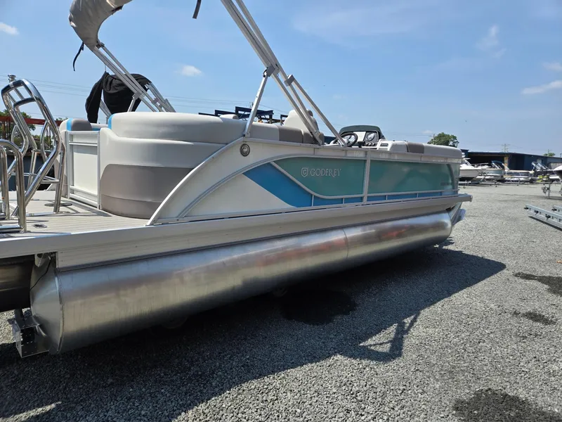Slide: The Image of 2026 Godfrey SWEETWATER 2286 SB pontoon boat on gravel lot under clear sky. - 5