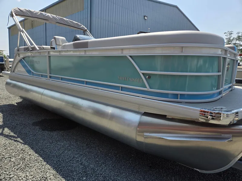 Slide: The Image of 2026 Godfrey SWEETWATER 2286 SB pontoon boat with blue siding and silver pontoons. - 7