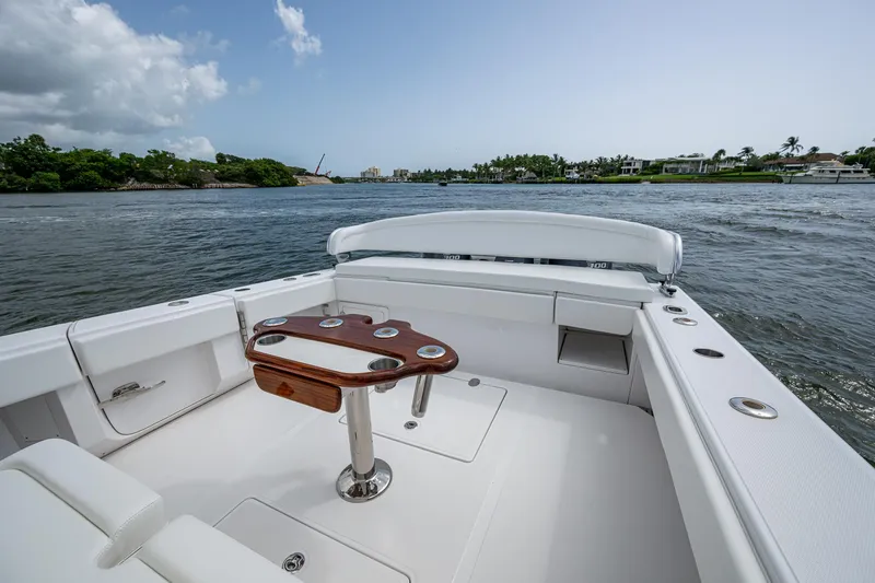 Slide: The Image of 2015 Bahama 41 boat interior with sleek seating and wooden table on calm water. - 10