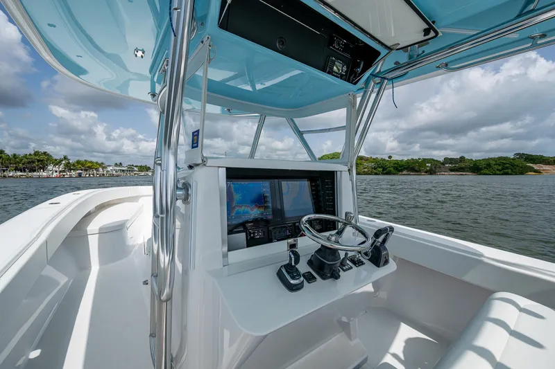 Slide: The Image of 2015 Bahama 41 boat cockpit with modern navigation equipment, steering wheel, and ocean view. - 20